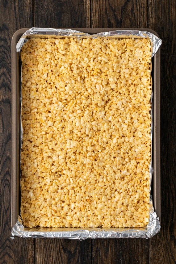 Rice krispie treat mixture pressed evenly into a 9x13 baking pan lined with foil.