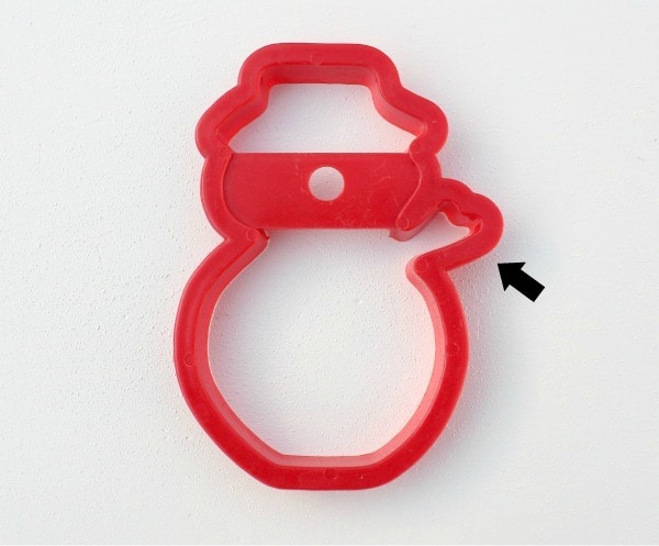 Red snowman cookie cutter with an arrow pointing to the scarf
