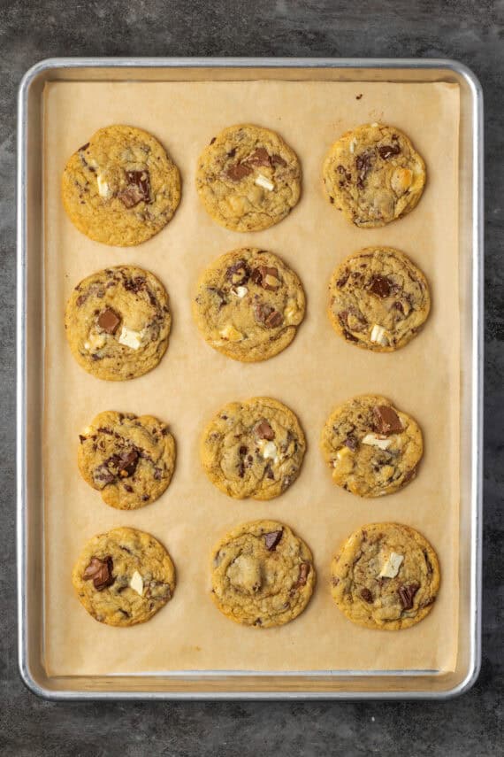 Overhead view of baked triple chocolate cookies on a parchment-lined baking sheet.