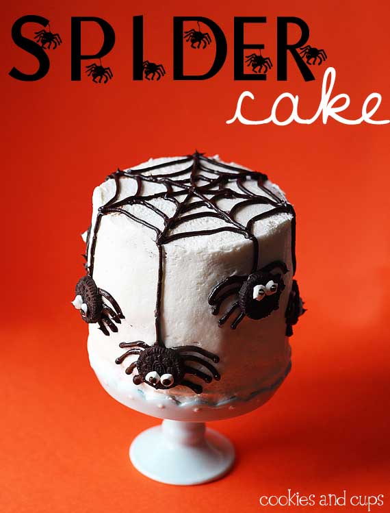 White cake with spiderweb decorations on a white cake stand