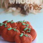 Pumpkin whoopie pies decorated to look like pumpkins on a plate.