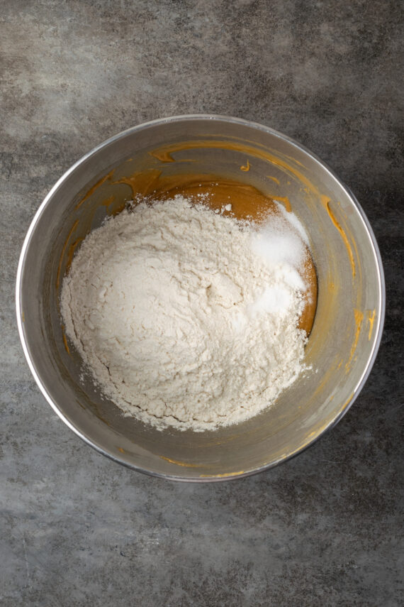Dry ingredients added the wet blondie batter in a metal bowl.