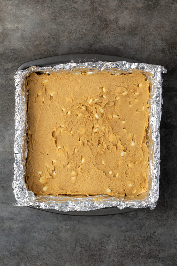 Butterscotch blondie batter in a foil-lined square baking pan.