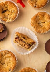 Overhead view of a cookie cup with a bite missing inside a cupcake wrapper, surrounded by more cookie cups.