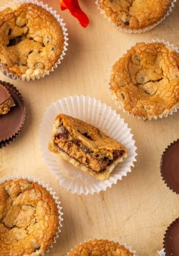 Overhead view of a cookie cup with a bite missing inside a cupcake wrapper, surrounded by more cookie cups.