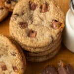 Overhead view of a stack of Milky Way cookies next to chopped Milky Way candy bars and a jug of milk.