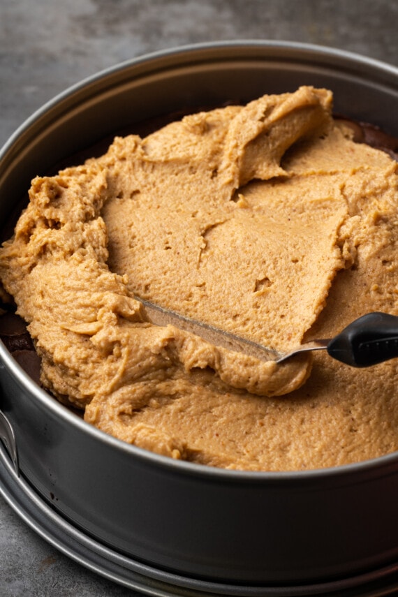 Peanut butter mousse spread over the fudge layer in a springform pan.