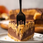 A slice of Reese's pie on a plate, with a fork stuck into the end.