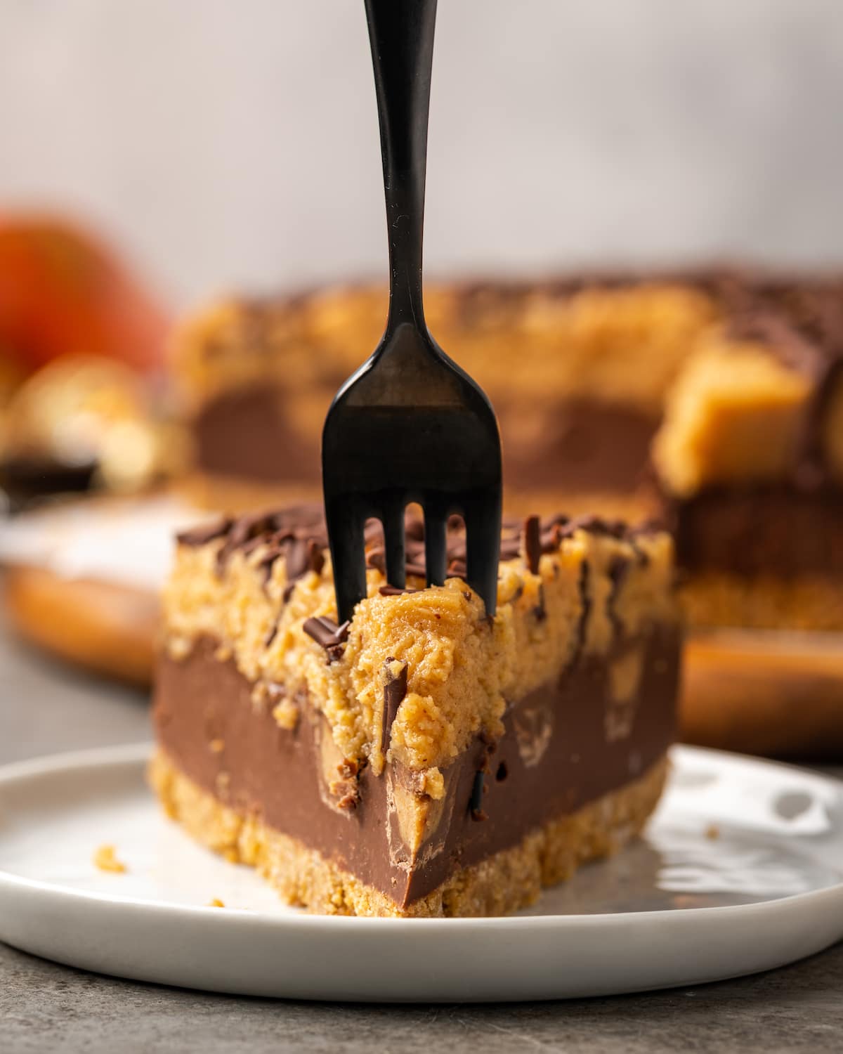 A slice of Reese's pie on a plate, with a fork stuck into the end.