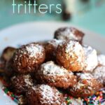 Funfetti fritters topped with powdered sugar on a plate