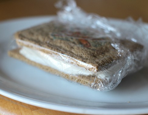An ice cream sandwich wrapped in plastic wrap.