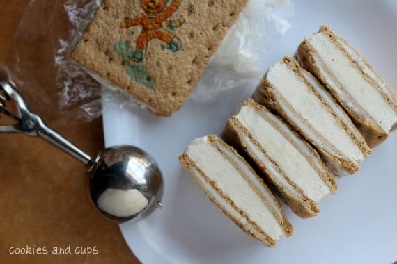 Gingerbread Pop Tart ice cream sandwiches stacked in a row on a plate, next to an ice cream scoop.