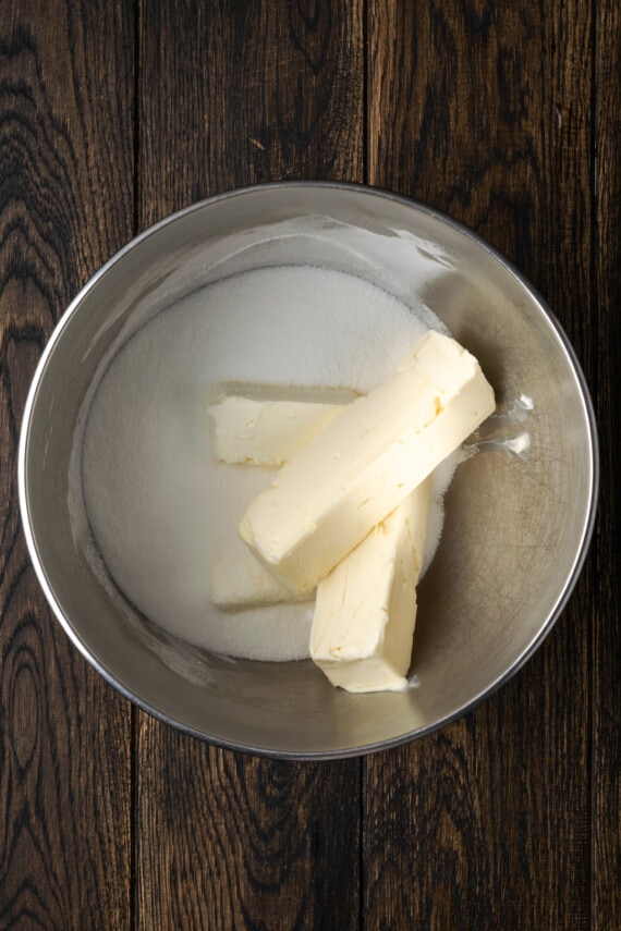 Butter sticks and sugar in a mixing bowl.