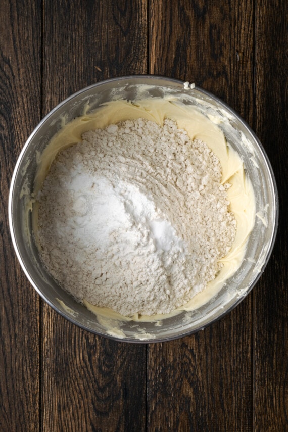 Dry ingredients added to creamed butter and sugar in a mixing bowl.