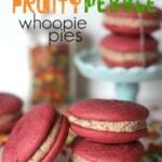 Pink Velvet Fruity Pebble whoopie pies stacked in front of a cake stand