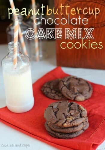 Stacked peanut butter cup chocolate cake mix cookies with milk on a red napkin