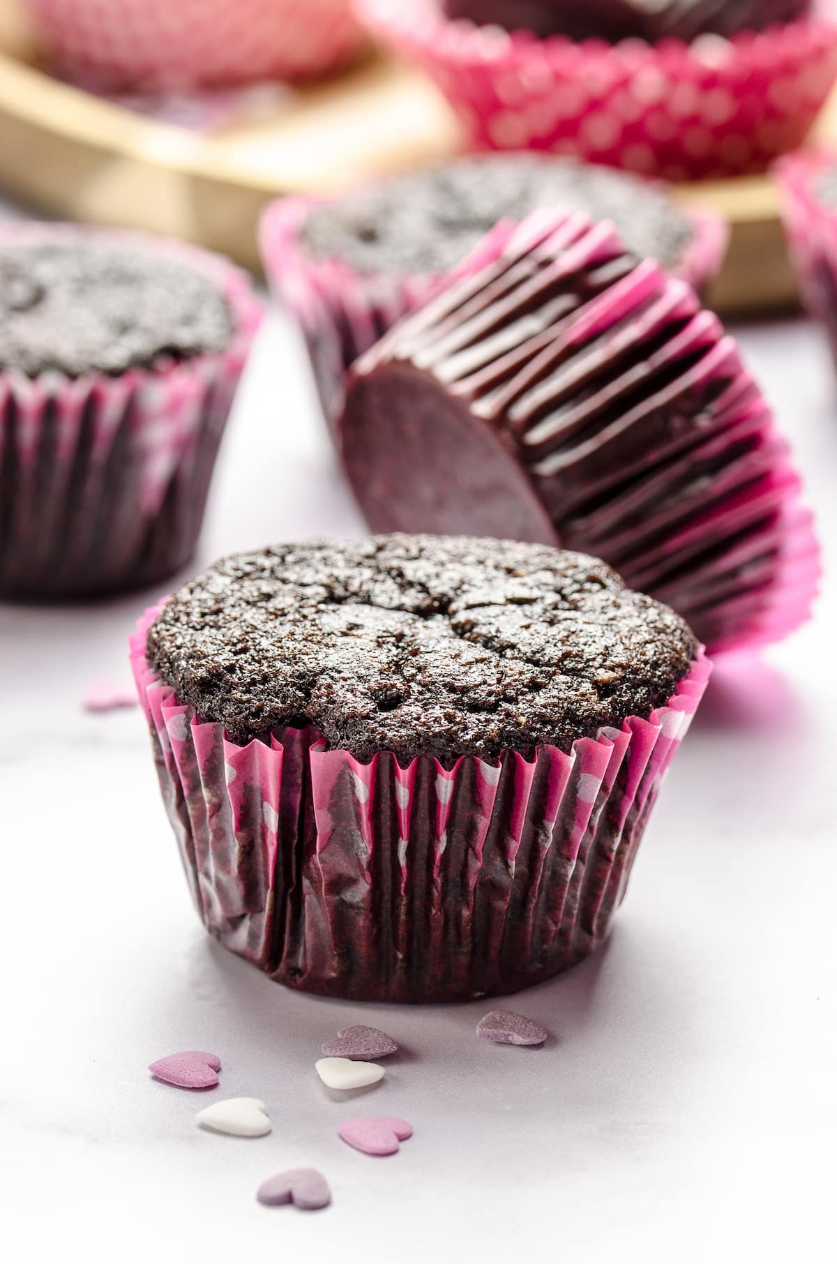 Unfrosted chocolate cupcakes in pink cupcake liners.