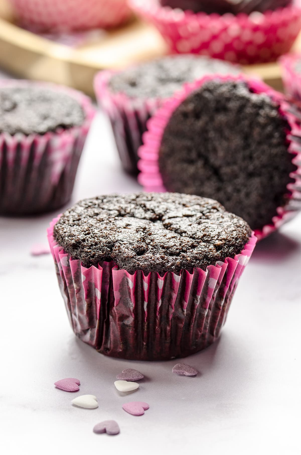 Unfrosted dark chocolate cupcakes in pink cupcake liners.