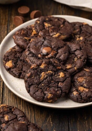 A pile of peanut butter chocolate cookies arranged on a white plate.