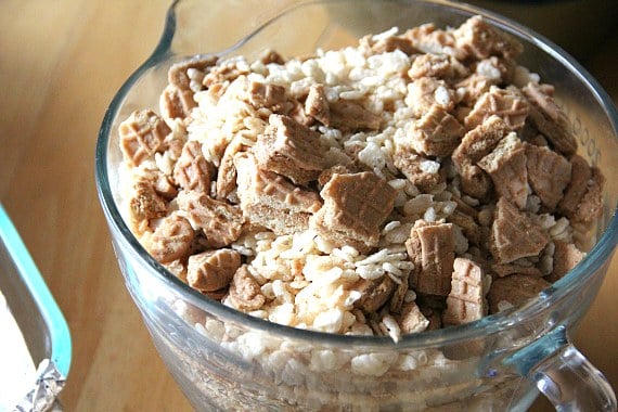 Crushed Nutter Butter cookies are added into a mixing bowl with a rice krispie marshmallow mixture.