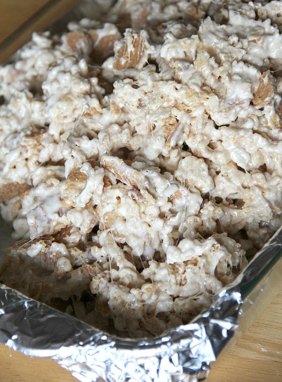 Nutter butter rice krispie treat mixture sets in a glass baking dish.