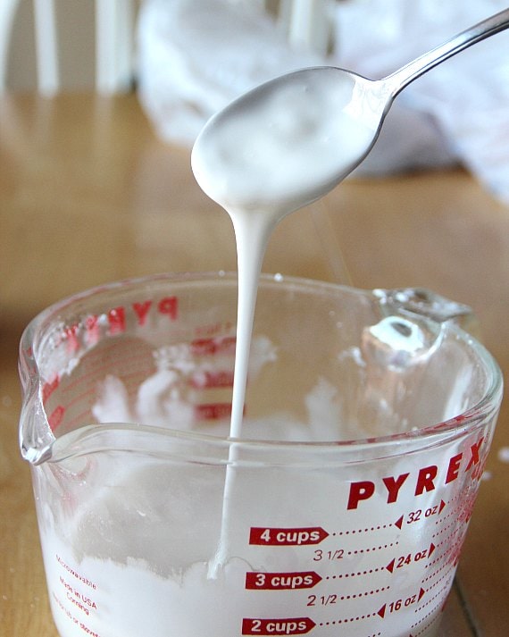 White glaze is stirred in a measuring cup.