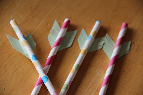 Colorful cupid's arrows crafted from straws and cutout paper.