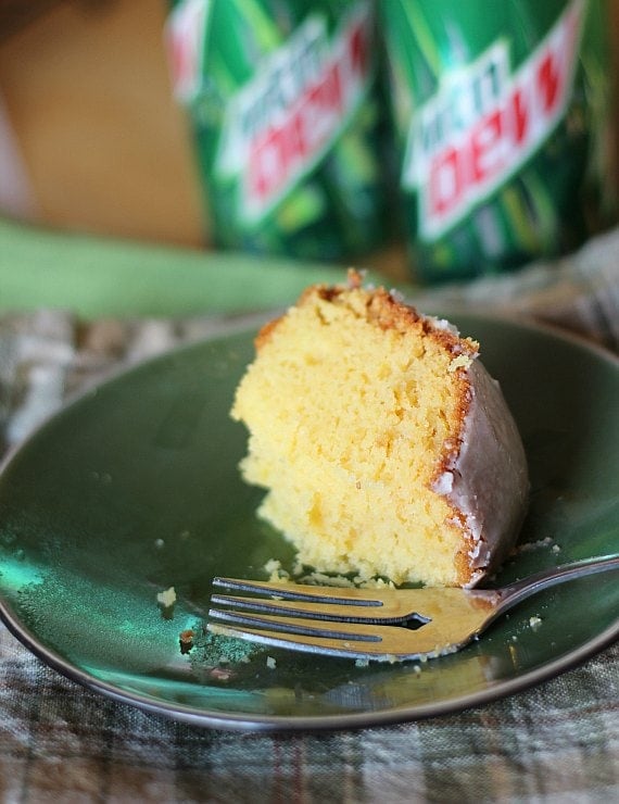 A slice of Mountain Dew cake on a plate, with a forkful missing.