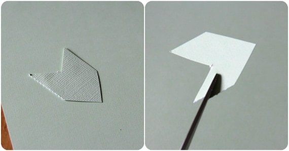 A cupid's arrow shape is cut out from paper.
