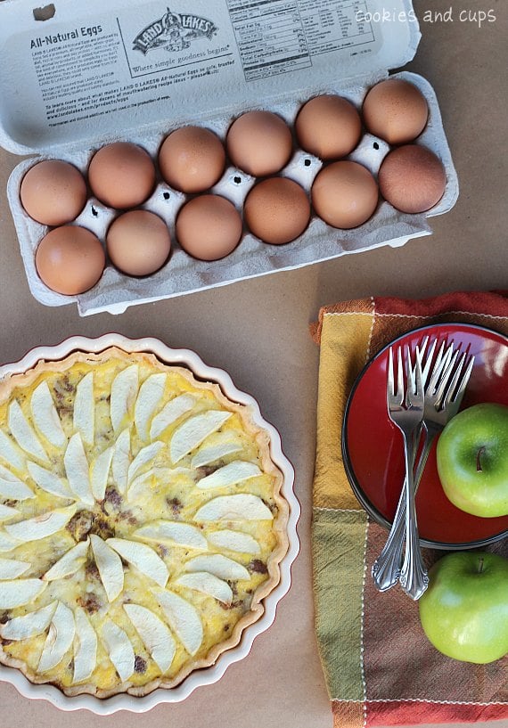 Overhead view of Egg, Apple, Cheese, and Sausage tart with ingredients nearby