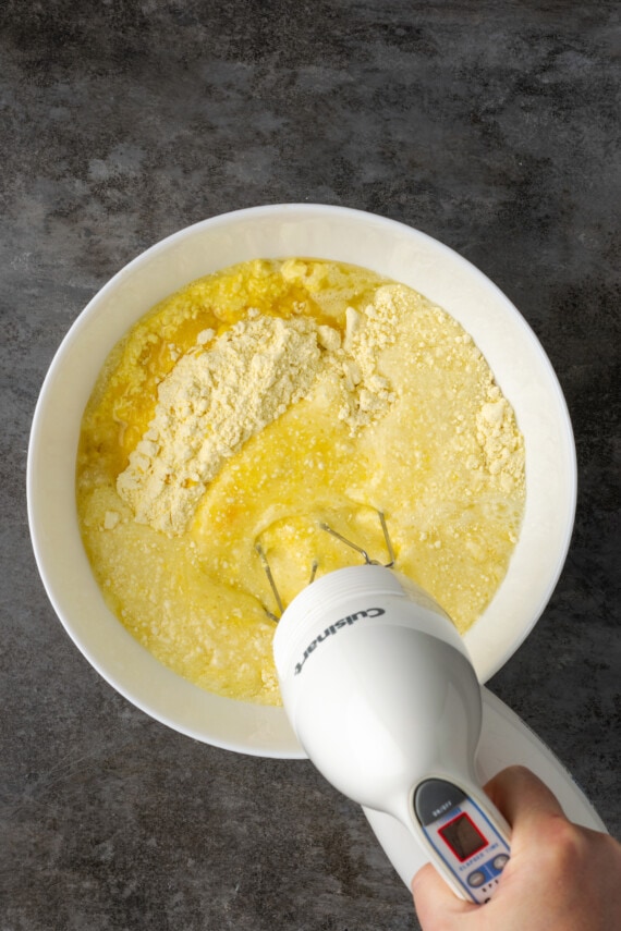 A hand mixer is used to mix the dough for Mountain Dew cake.
