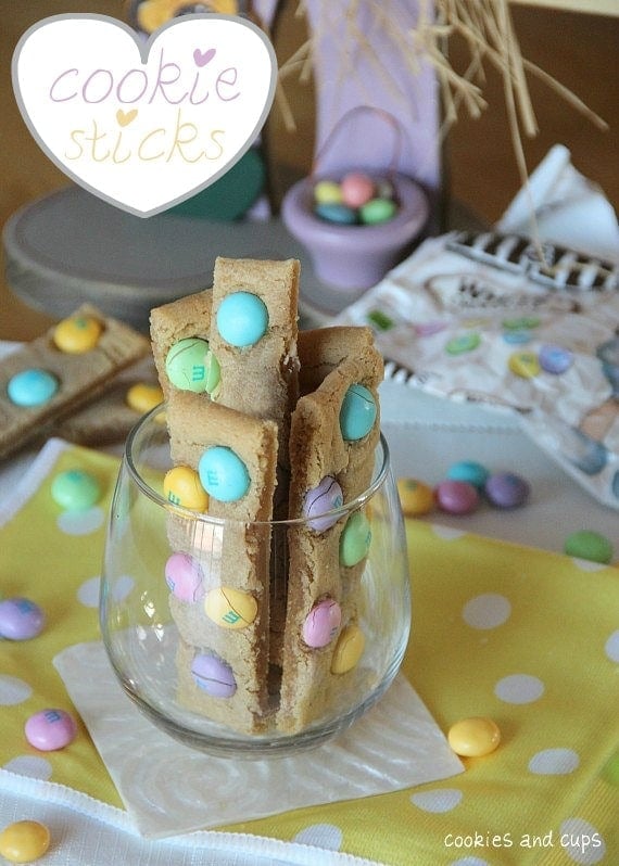 Cookie sticks with pastel candies in a clear glass