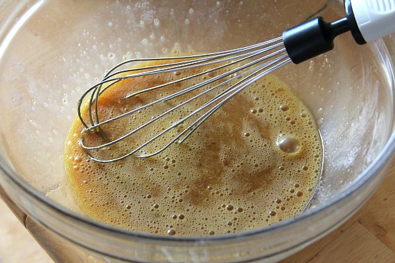 Honey and peanut butter is whisked together in a clear bowl.