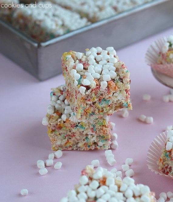 A stack of Fruity Pebbles Rice Krispie Treats with scattered Marshmallow Bits.