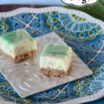 Two key lime fudge bars on a square white plate.