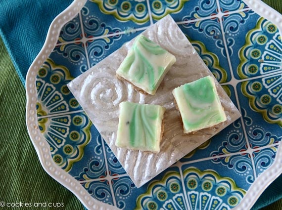 Top view of three key lime fudge bars on a white square plate.