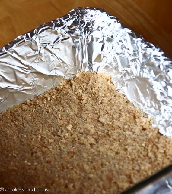 A lined baking pan filled with a crumb crust.