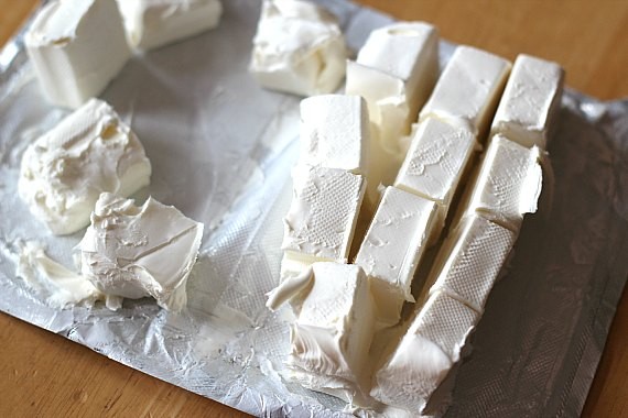 A block of cream cheese cut into cubes.