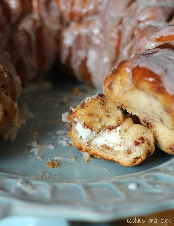 Monkey bread is served on a plate, with one piece pulled apart.