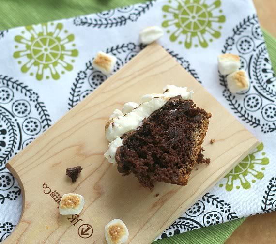 Half of a S'mores cupcake on a wooden cutting board