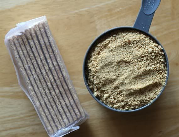 Top view of a sleeve of graham crackers and a cup of graham cracker crumbs
