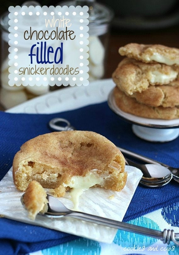 White Chocolate filled snickerdoodle cookie on a napkin with a bite removed