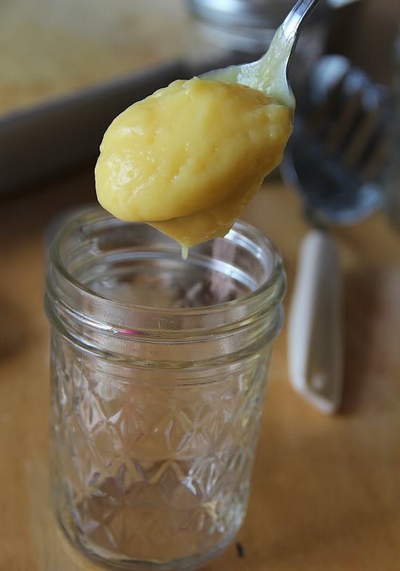 A spoonful of vanilla pudding being put in a jar