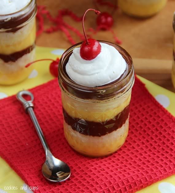 Boston Cream Pie in a Jar topped with whipped cream and a cherry