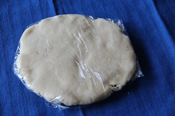 A disc of dough wrapped in plastic wrap