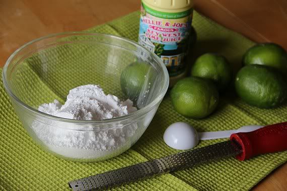 A bowl of powdered sugar and several limes