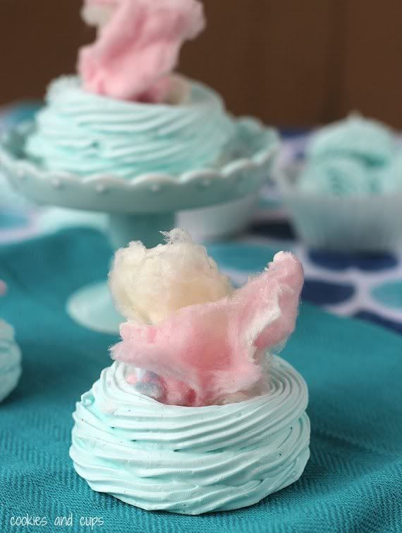 Pieces of pink and yellow cotton candy inside baked blue meringue cups