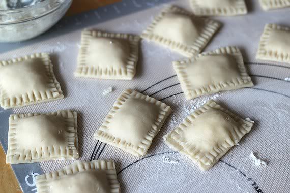 Filled dough squares on a baking mat