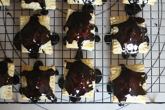 Pastry squares drizzled with melted chocolate on a cooling rack