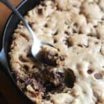 A Skillet Chocolate Chip Cookie with a Spoon Digging in